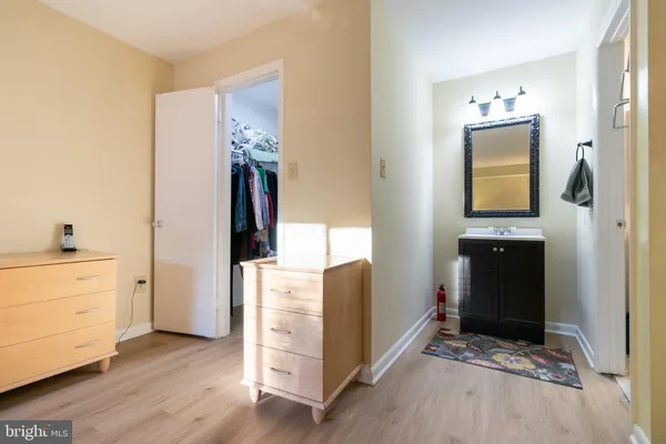a view of a hallway with wooden floor and cabinet
