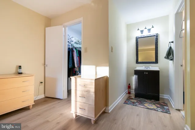 a view of a hallway with wooden floor and cabinet