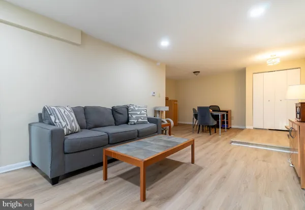 a living room with furniture a dining table and a piano with wooden floor