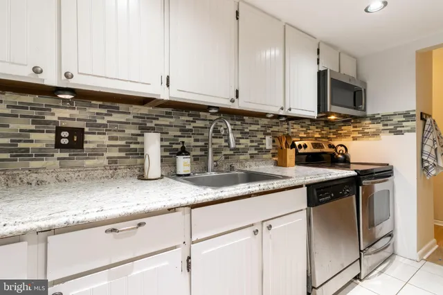 a kitchen with stainless steel appliances granite countertop a sink a stove and a microwave