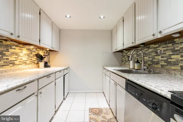 a kitchen with granite countertop white cabinets and sink