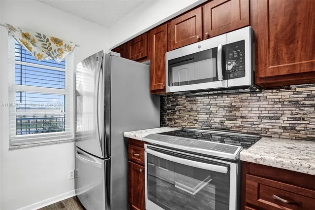 a view of a kitchen with a sink and a refrigerator