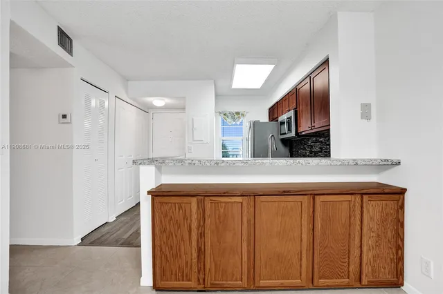 a view of a kitchen with a sink and a ceiling fan