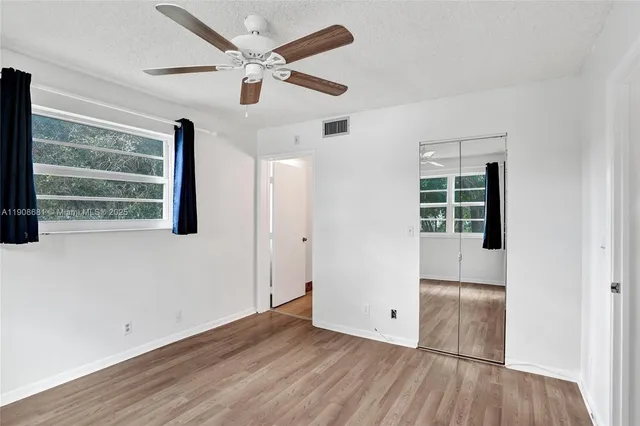 a view of an empty room with wooden floor