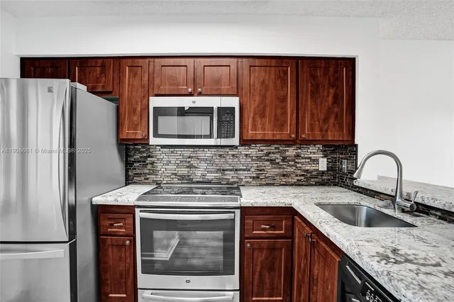 a kitchen with stainless steel appliances granite countertop a sink stove and refrigerator