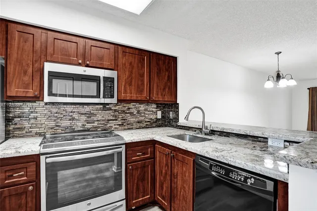 a kitchen with stainless steel appliances granite countertop a refrigerator and a sink