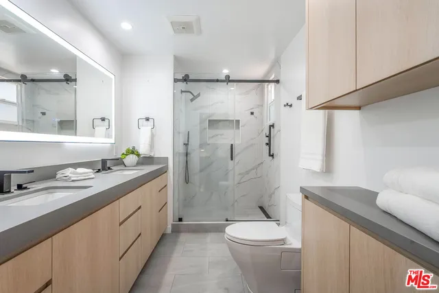 a bathroom with a granite countertop sink toilet a shower and a mirror