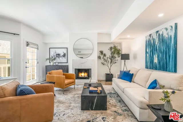 a living room with furniture fireplace and a large window