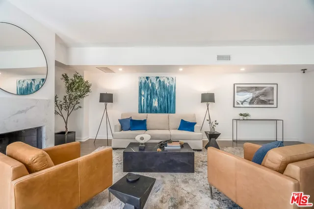 a living room with furniture a fireplace and a large mirror