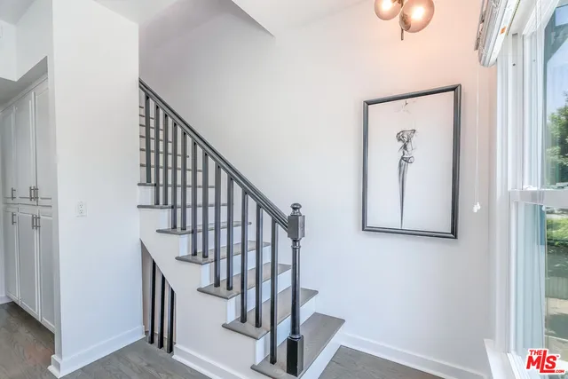 a view of staircase with railing and white walls