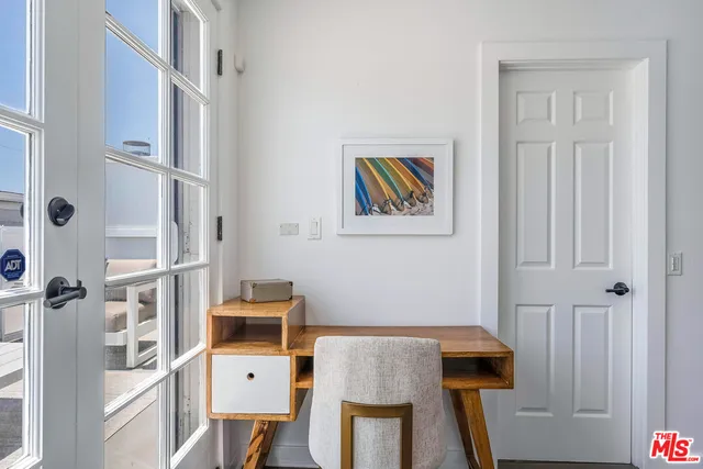 a view of a workspace with furniture and a window