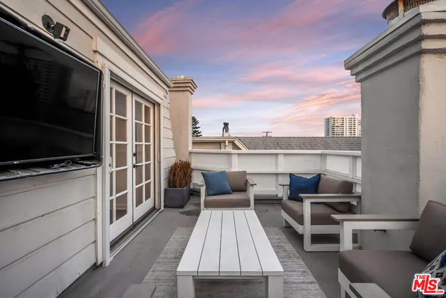 a balcony with a couch and wooden floor