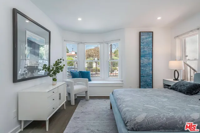 a bedroom with a bed and a potted plant