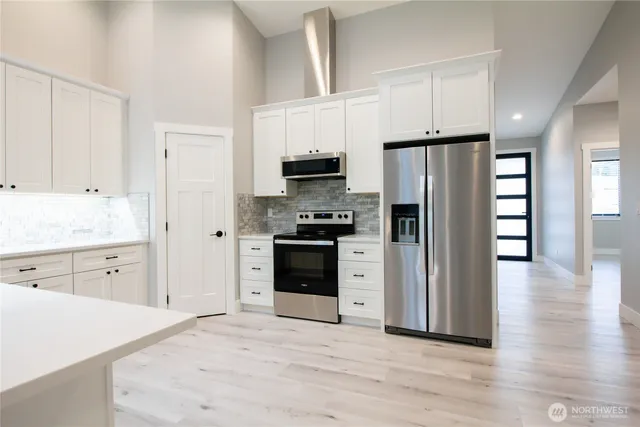 a kitchen with granite countertop a refrigerator and a stove top oven