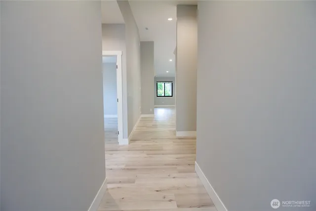 a view of a hallway with wooden floor and staircase