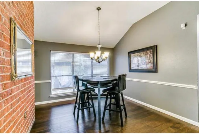 a dining room with furniture a chandelier and wooden floor