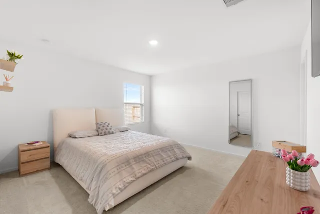 a bedroom with a bed and a potted plant