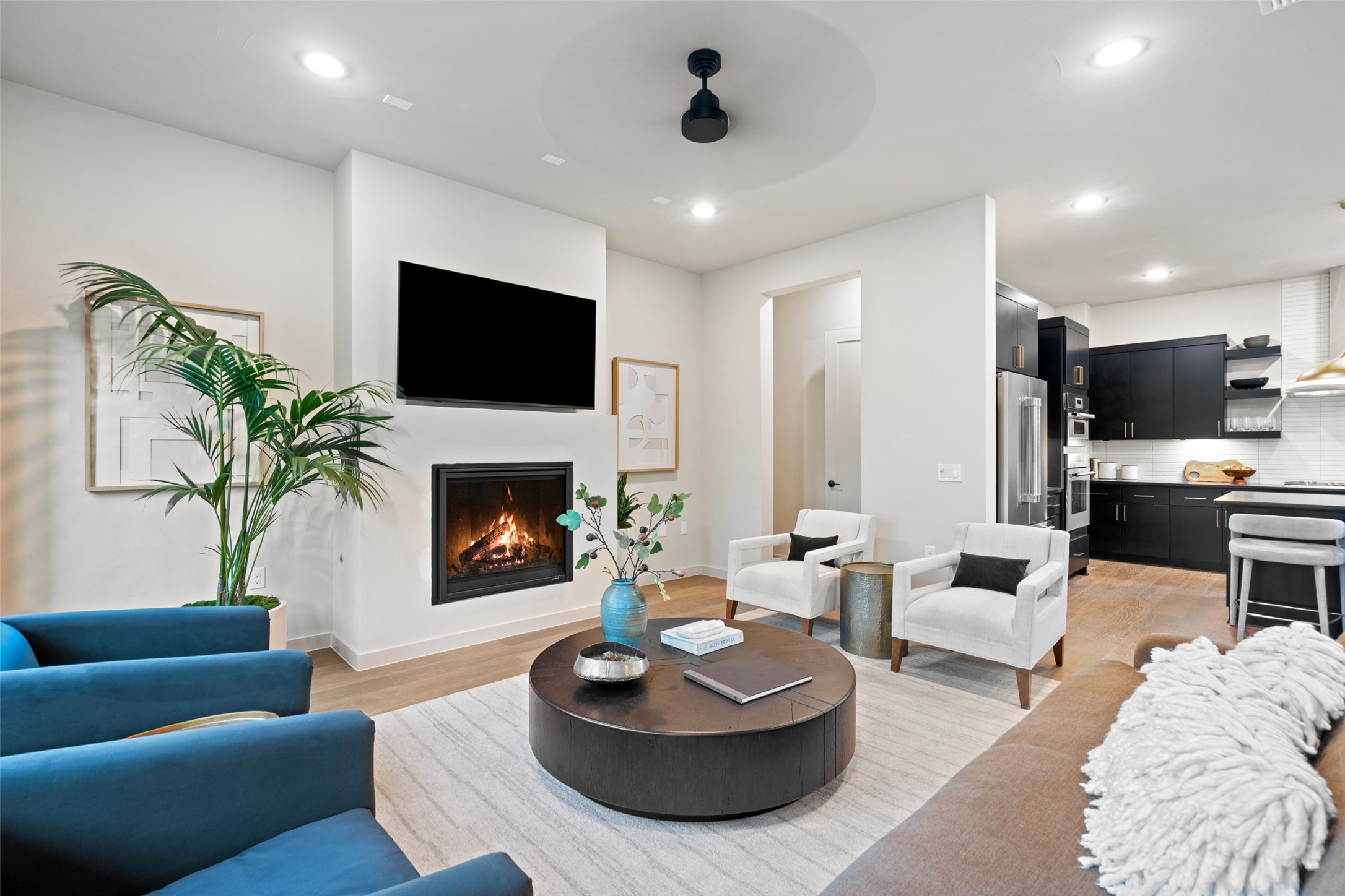 9803 Ribelin Ranch Court, Unit 19 Austin, TX 78750 - Photo 4 of 14 A striking fireplace with a television above anchors this contemporary open-concept living space, blending comfort with modern design.