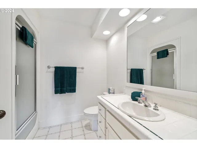 a bedroom with two beds and next to a window