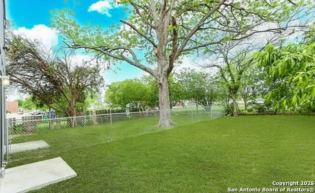 a backyard of a house with lots of green space and fountain