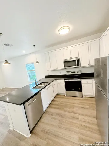 a kitchen with stainless steel appliances kitchen island granite countertop a stove a sink and a microwave