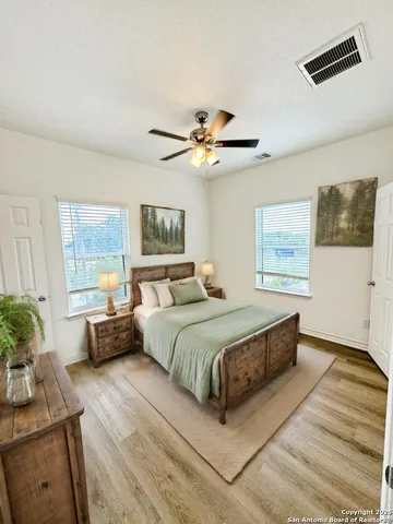 a spacious bedroom with a bed a couch and a potted plant