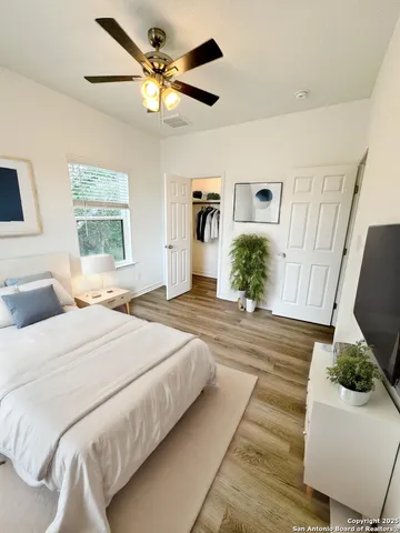 a bedroom with a bed dresser and wooden floor