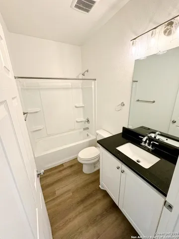 a bathroom with a granite countertop sink toilet a mirror and shower