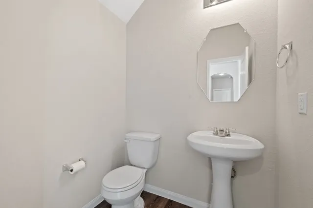 a bathroom with a toilet a sink and mirror