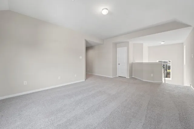 a view of an empty room with a kitchen