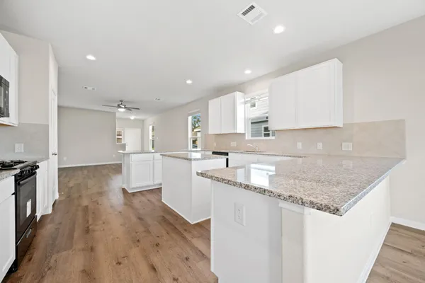 a kitchen with granite countertop a sink stove and refrigerator