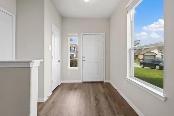 a view of a hallway with wooden floor and a window