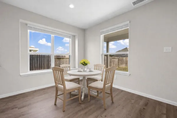 a dining room with furniture a rug and wooden floor