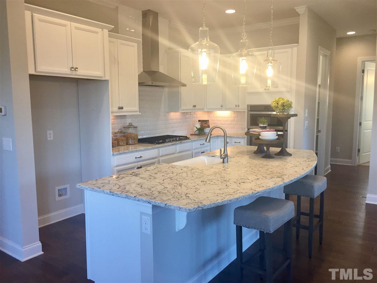 5264 Aleppo Lane, Unit 51 Raleigh, NC 27613 - Photo 5 of 22 a kitchen with kitchen island granite countertop a sink a center island and cabinets