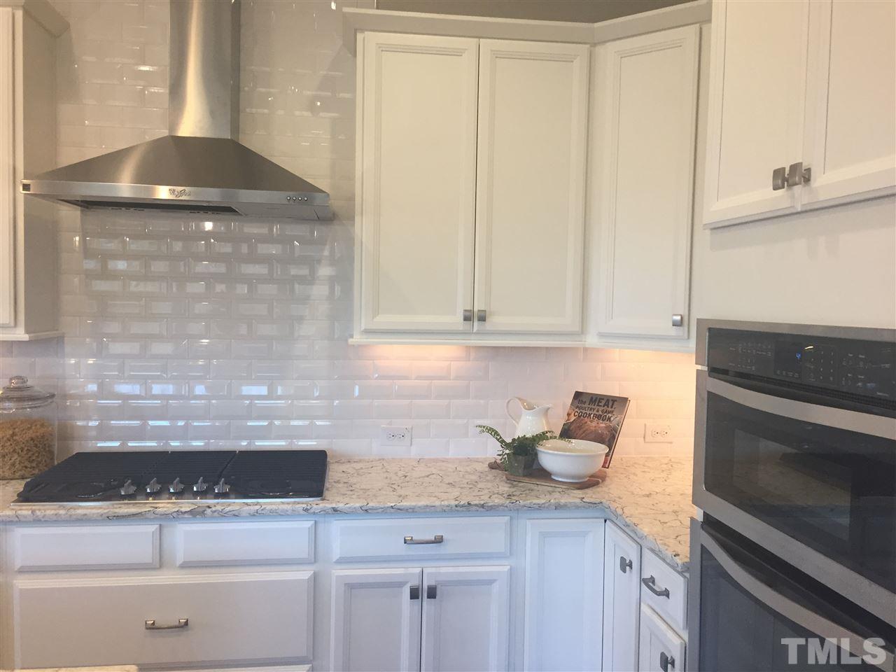 5264 Aleppo Lane, Unit 51 Raleigh, NC 27613 - Photo 7 of 22 a kitchen with granite countertop stainless steel appliances white cabinets and a granite counter tops