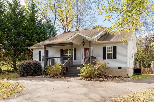 a front view of a house with a tree