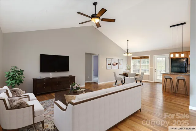 a living room with furniture a flat screen tv and a window