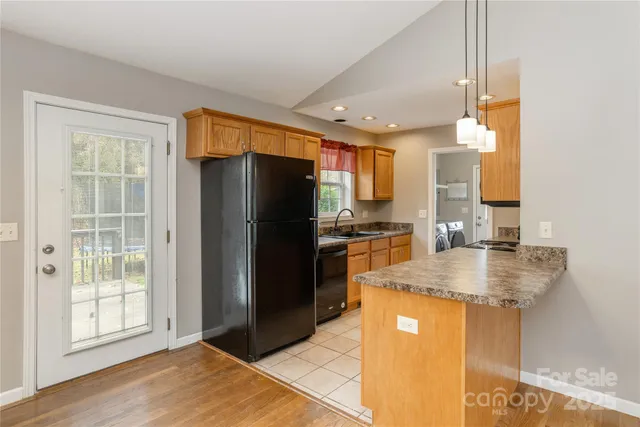 a kitchen with stainless steel appliances granite countertop a refrigerator a sink and a stove