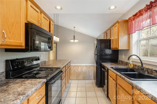 a kitchen with granite countertop a stove sink and cabinets