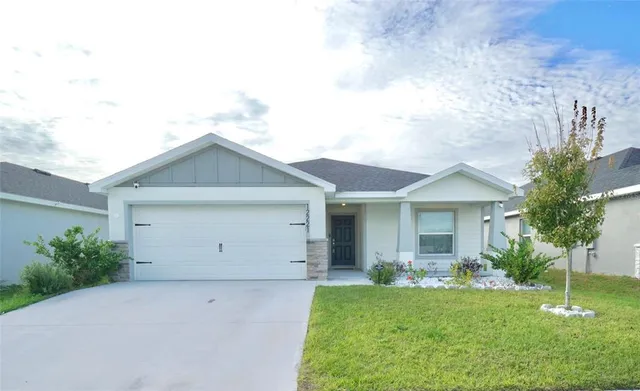 a view of a house with backyard and a tree