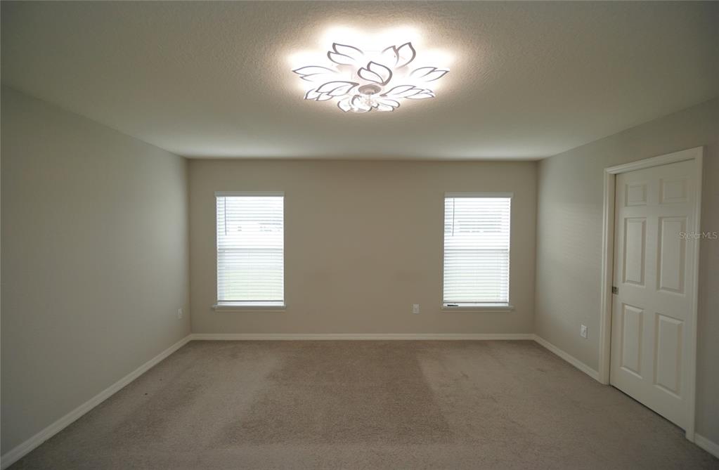 12221 Cypress Br Street Riverview, FL 33579 - Photo 17 of 20 an empty room with a window and a chandelier fan