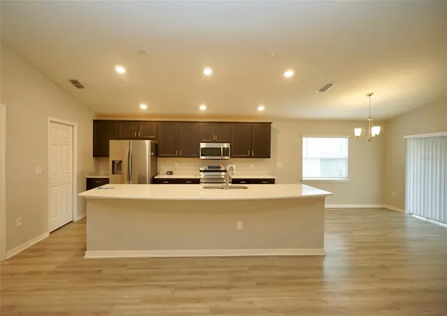 a view of kitchen with stainless steel appliances refrigerator sink and stove