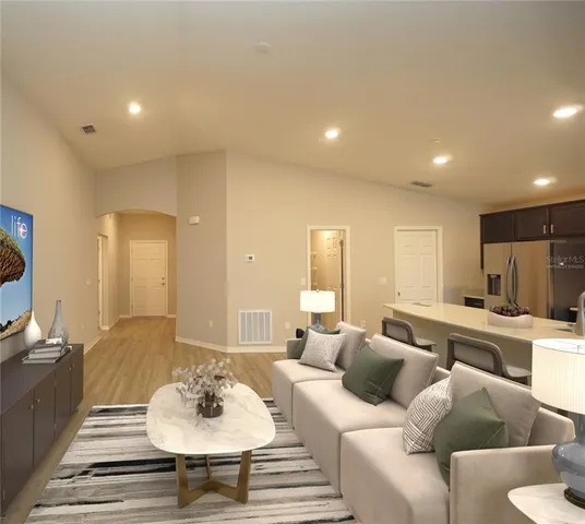 a living room with furniture and a wooden floor