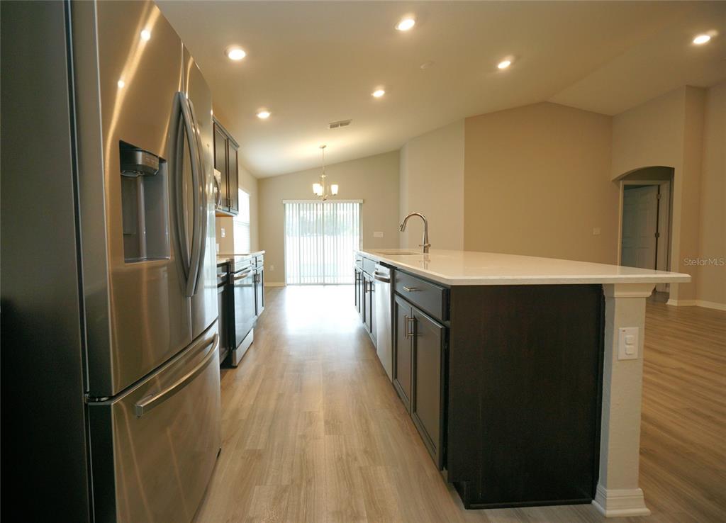 12221 Cypress Br Street Riverview, FL 33579 - Photo 8 of 20 a kitchen with stainless steel appliances kitchen island a refrigerator sink and cabinets