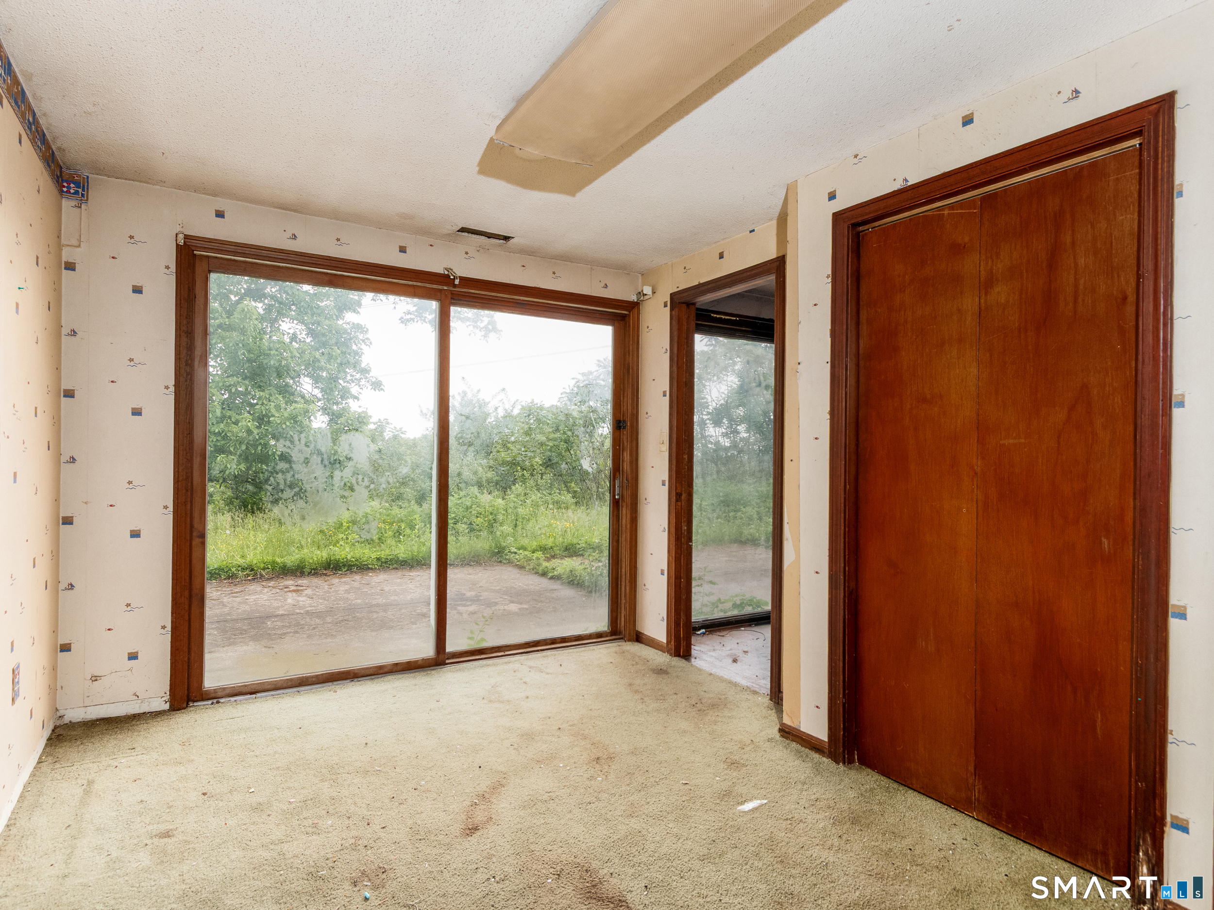63 High Hill Road Wallingford, CT 06492 - Photo 31 of 34 a view of an empty room with wooden floor and doors