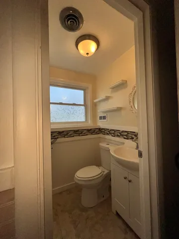 a bathroom with a granite countertop toilet and a sink