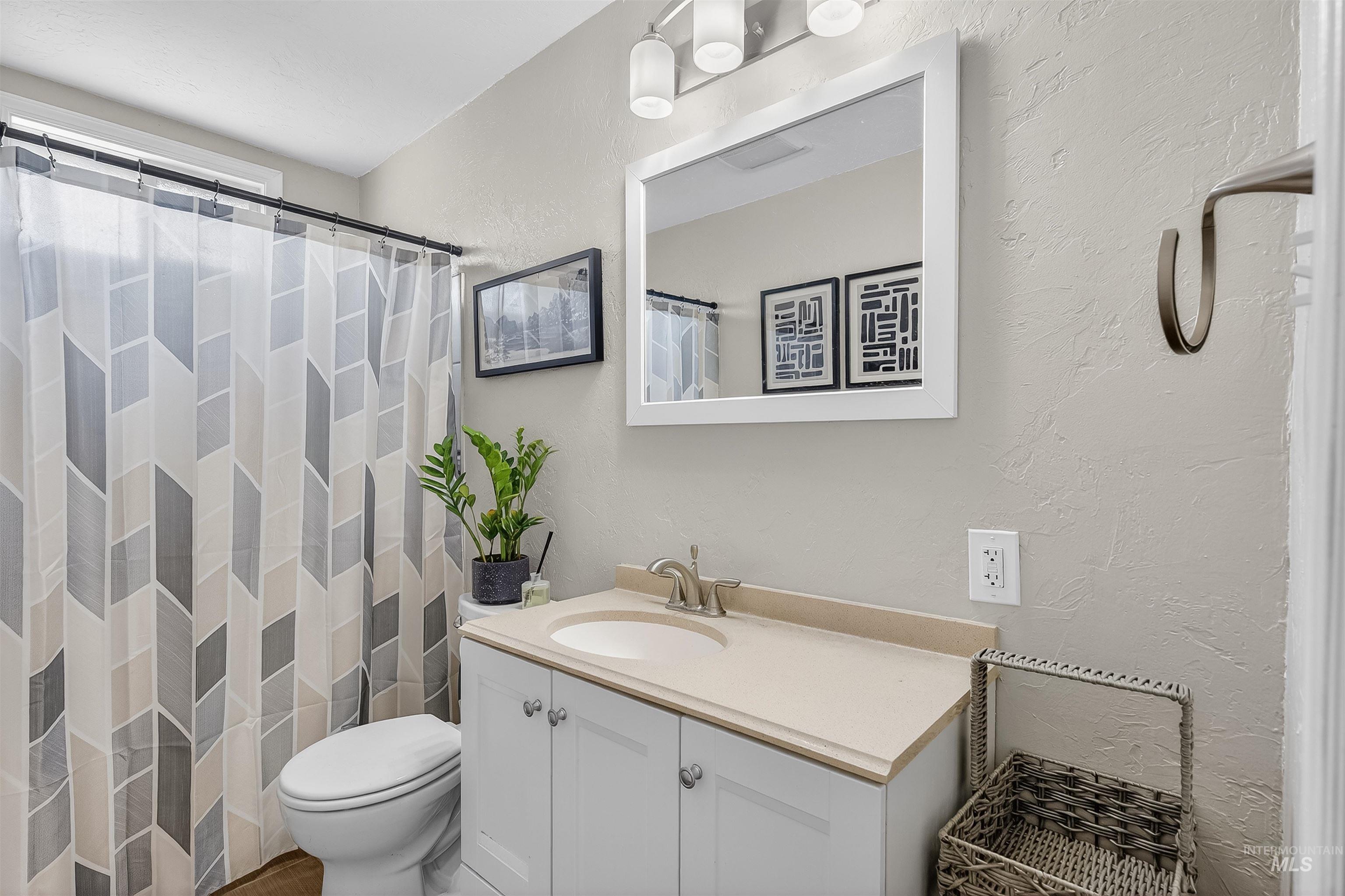 807 3rd Street Clarkston, WA 99403 - Photo 23 of 33 Full bathroom with vanity, a textured wall, and a shower with curtain