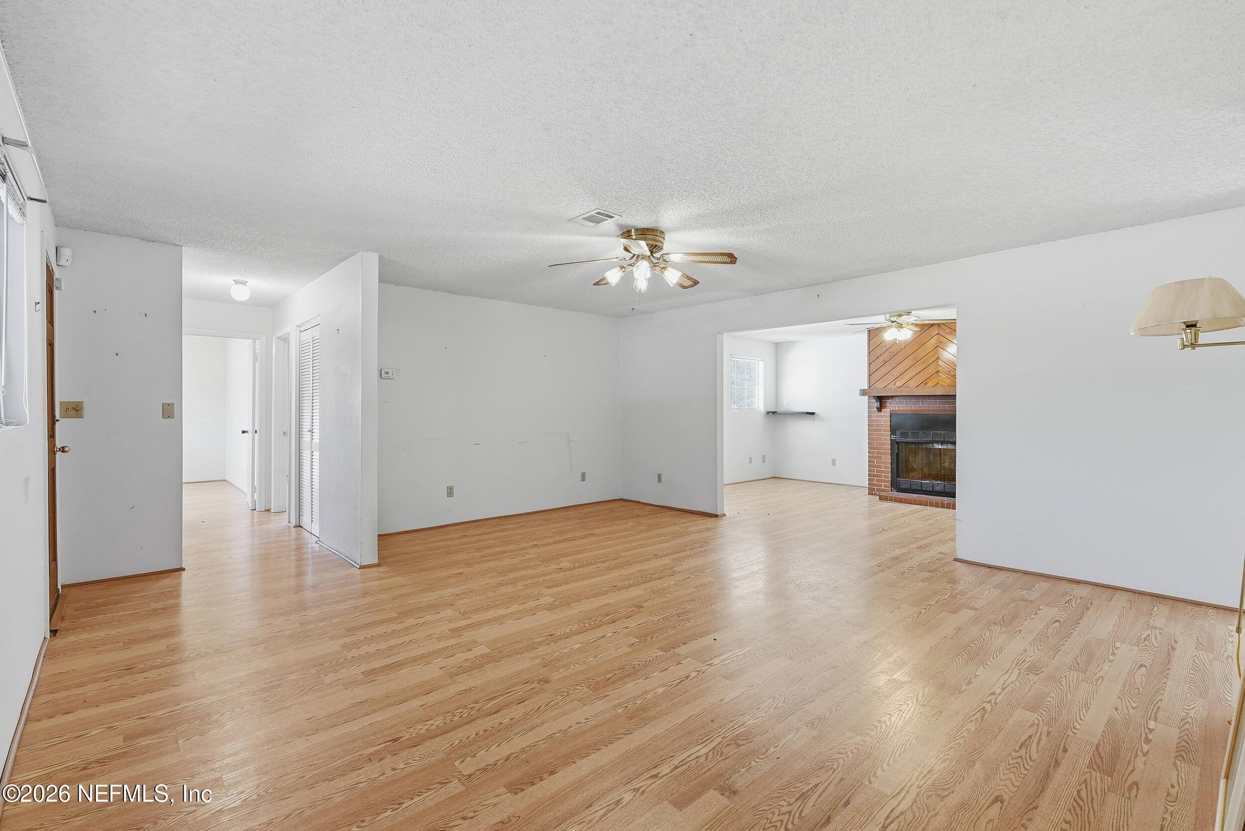 7593 Silver Sands Road Keystone Heights, FL 32656 - Photo 7 of 36 a view of an empty room with wooden floor and a ceiling fan