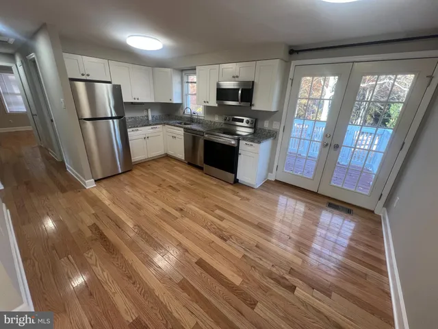 a kitchen with stainless steel appliances a refrigerator sink and microwave