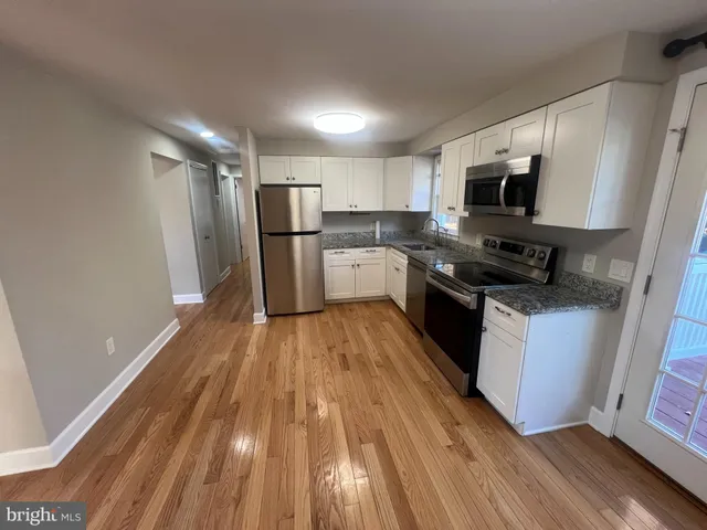 a kitchen with a sink and steel appliances